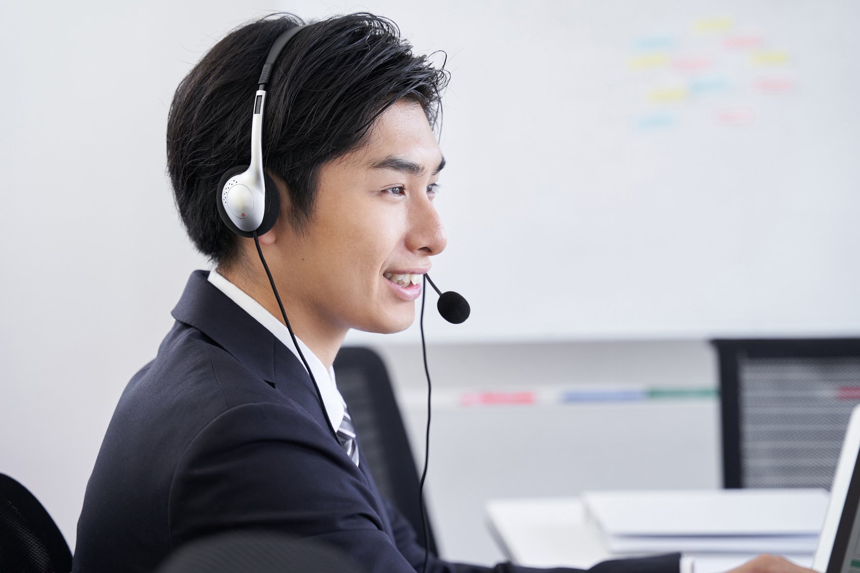 A Japanese male businessman in his office answering an inquiry